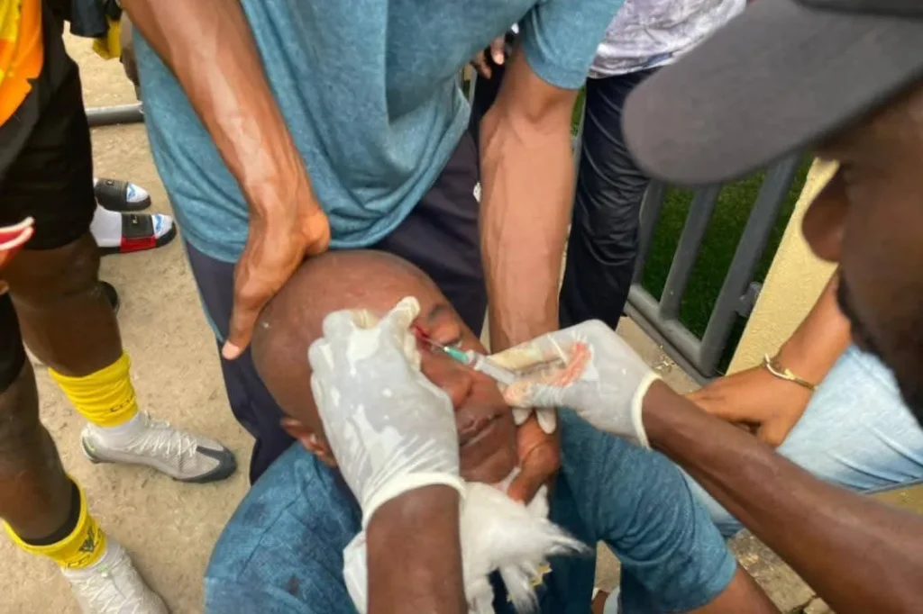 Medical team treating Doma United goalkeeper trainer on the field